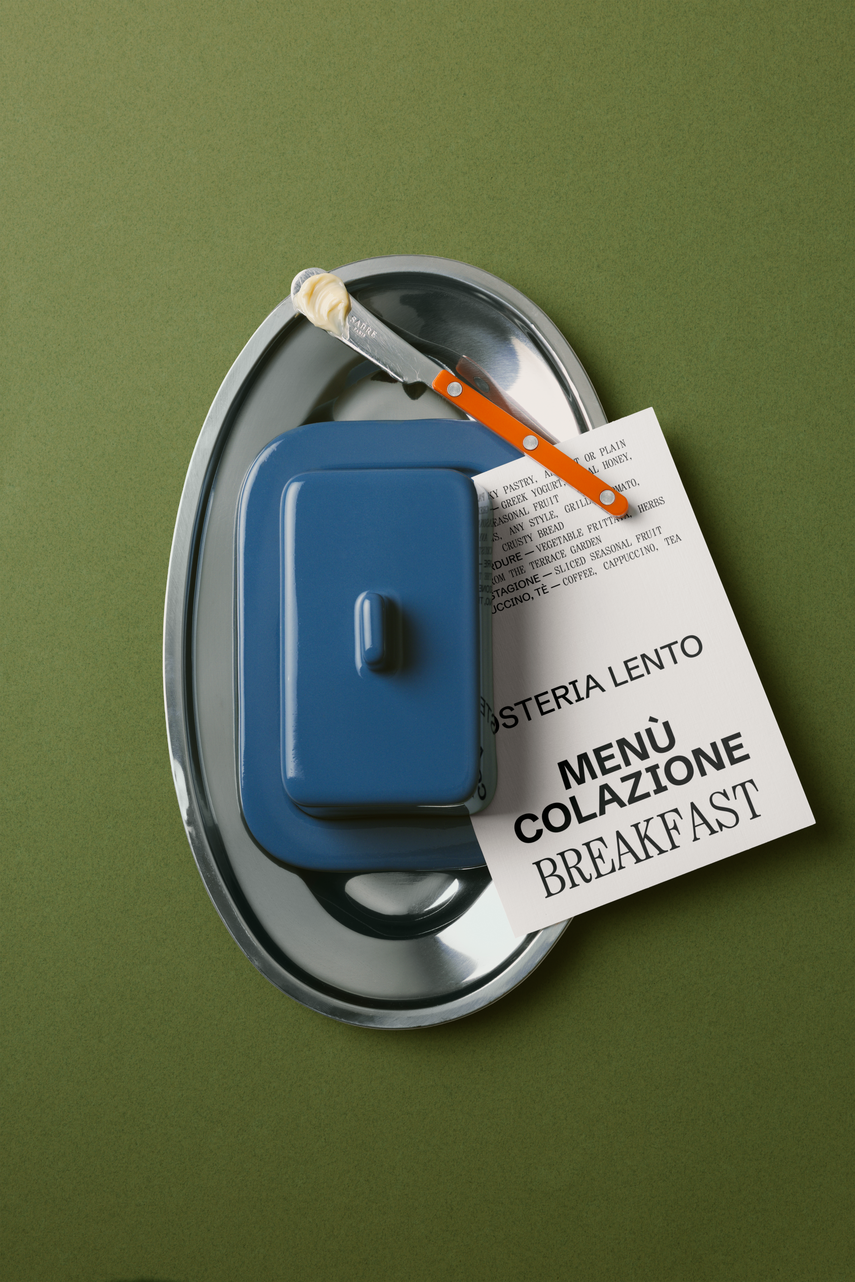 Branded menu on a plate with a knife and butter dish